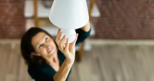 Woman changing LED lightbulb