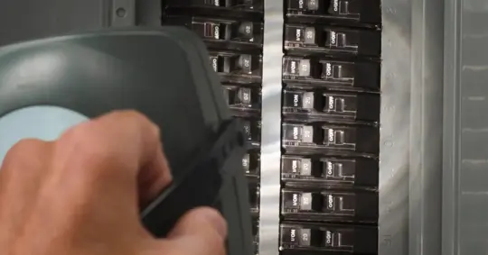 Man with flashlight at residential service panel