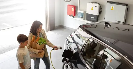Woman charging EV at home garage